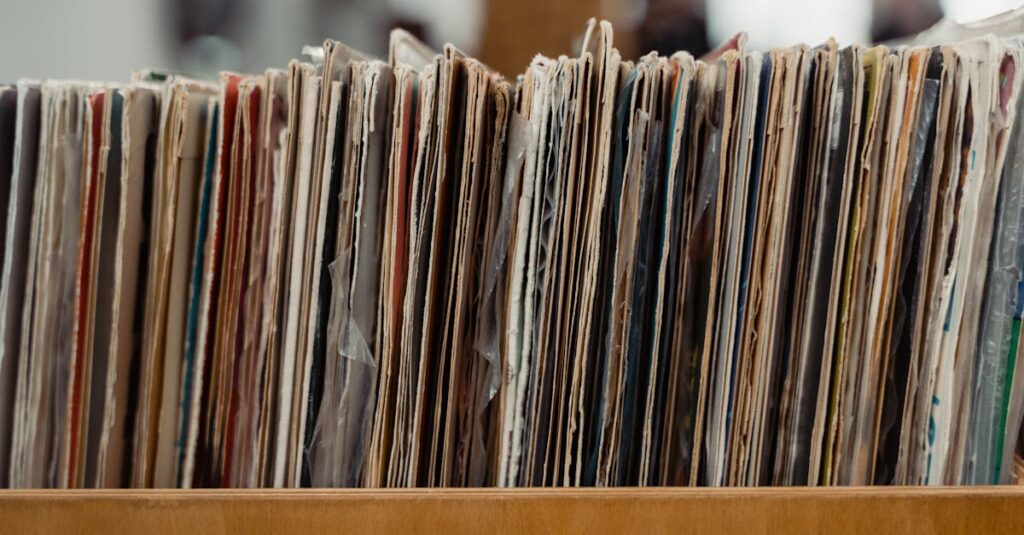 Stack of vintage vinyl records stored in a wooden crate, showcasing a retro vibe.